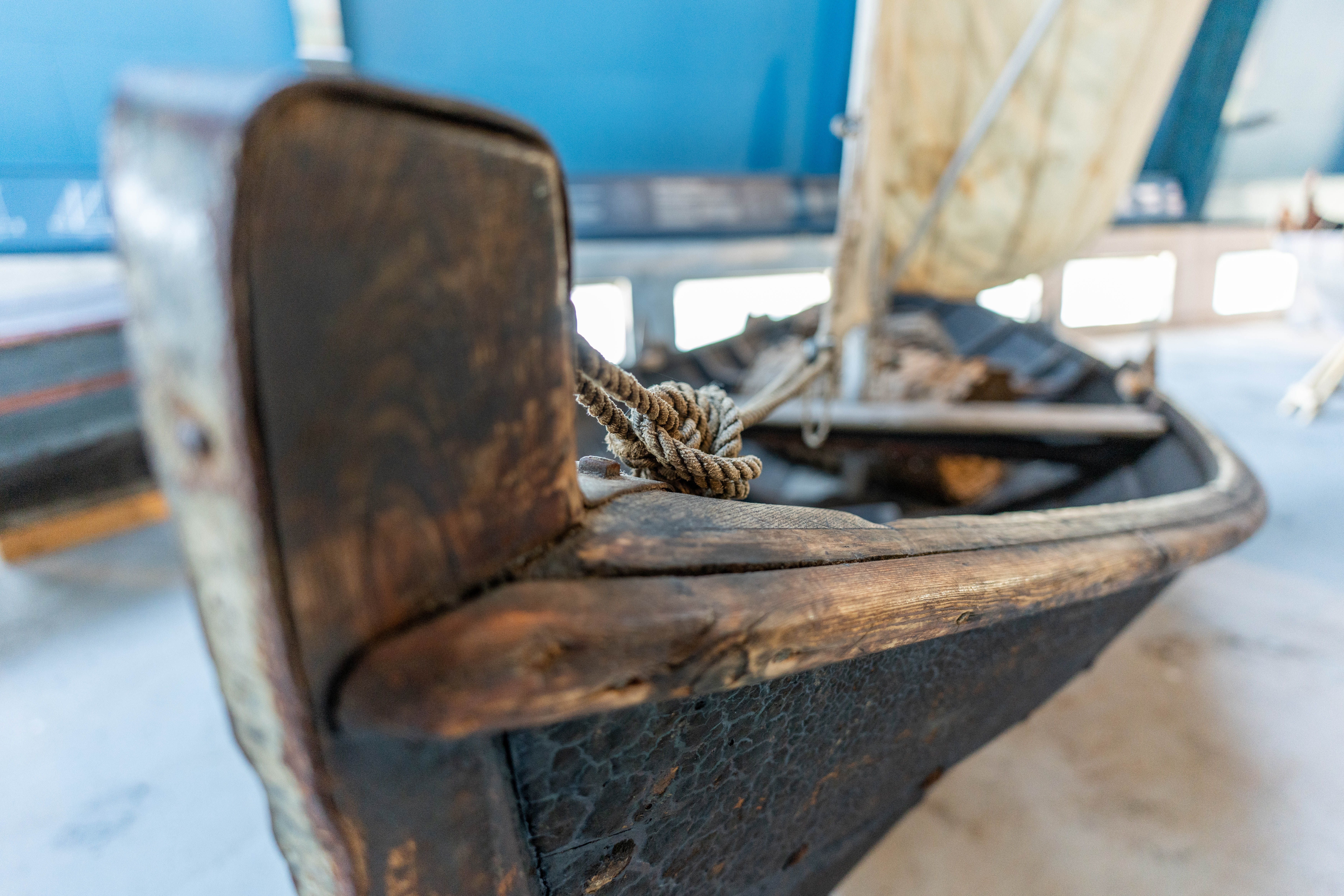 Nærbilde av kjølen på ein gaml trebåt med seg, inne i båthallen på Kystmuseet.