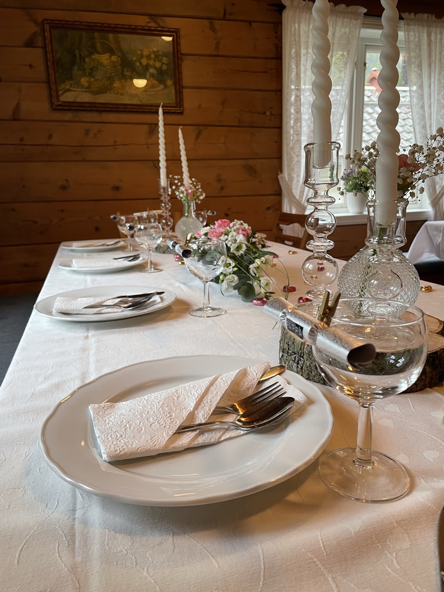 Dekorert bord i Halbrendshuset. Bordet er dekka og pynta med duk, serviettar, blomar og lysestaker.