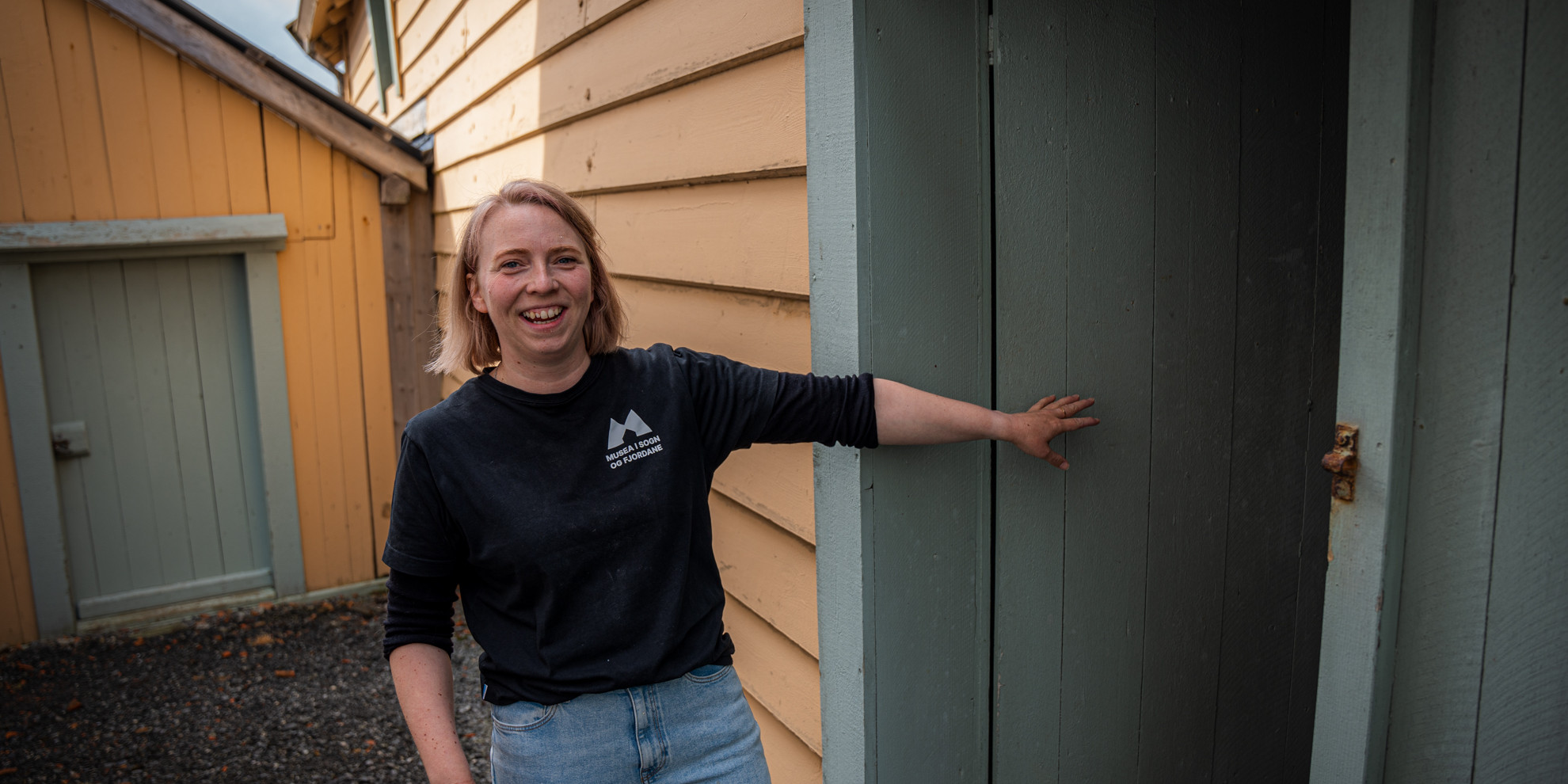 Smiling woman opens a door.