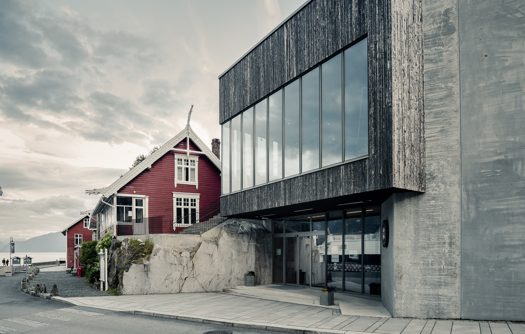 Fasaden på Norsk Reiselivsmuseum inklusiv eit gamalt hus i drakestil.
