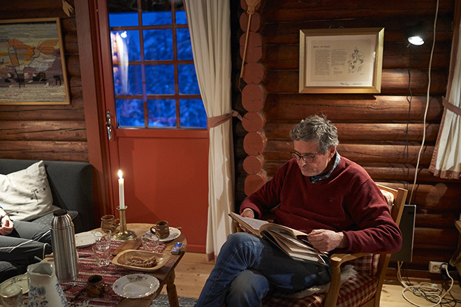 Man reads book inside cabin.