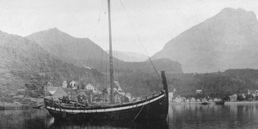 A black and white photo with four women looking at a anchored ship ancored up in the bay.