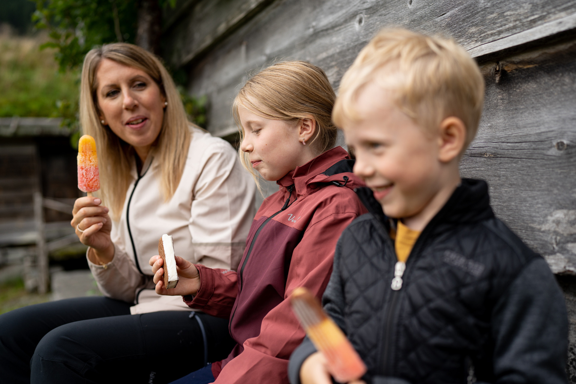 Ei dame og to born sit og et is.