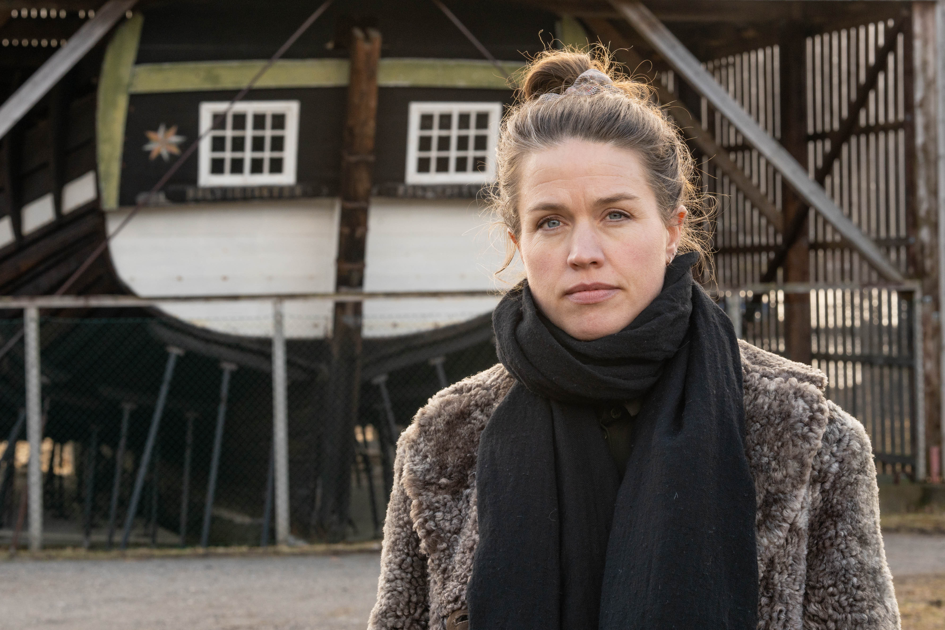 Nærbilde av Anne Kristin Moe med hekken på Holvikejekta i bakgrunnen.