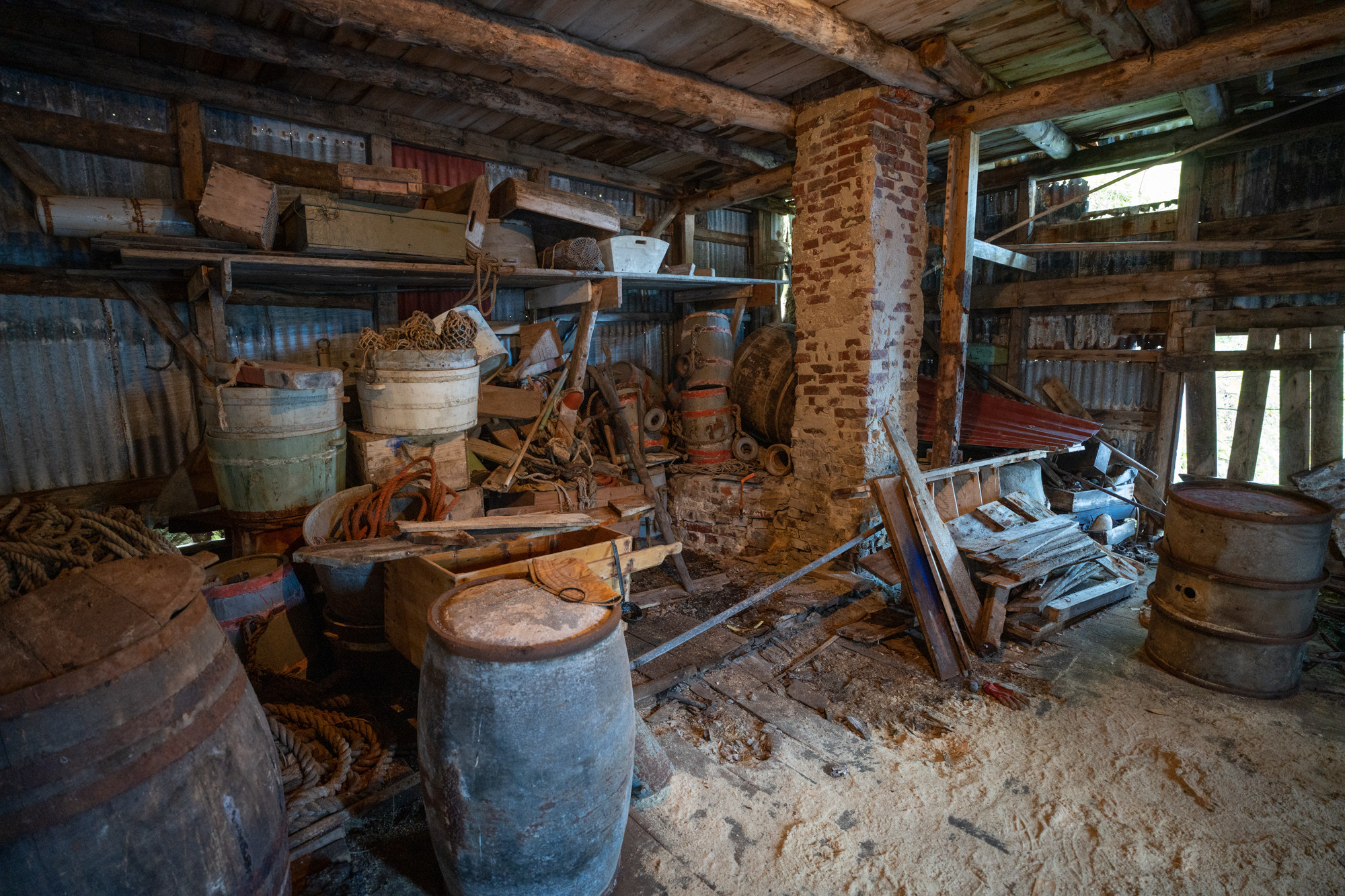 Lager fullt av gamle tønner og kassar.