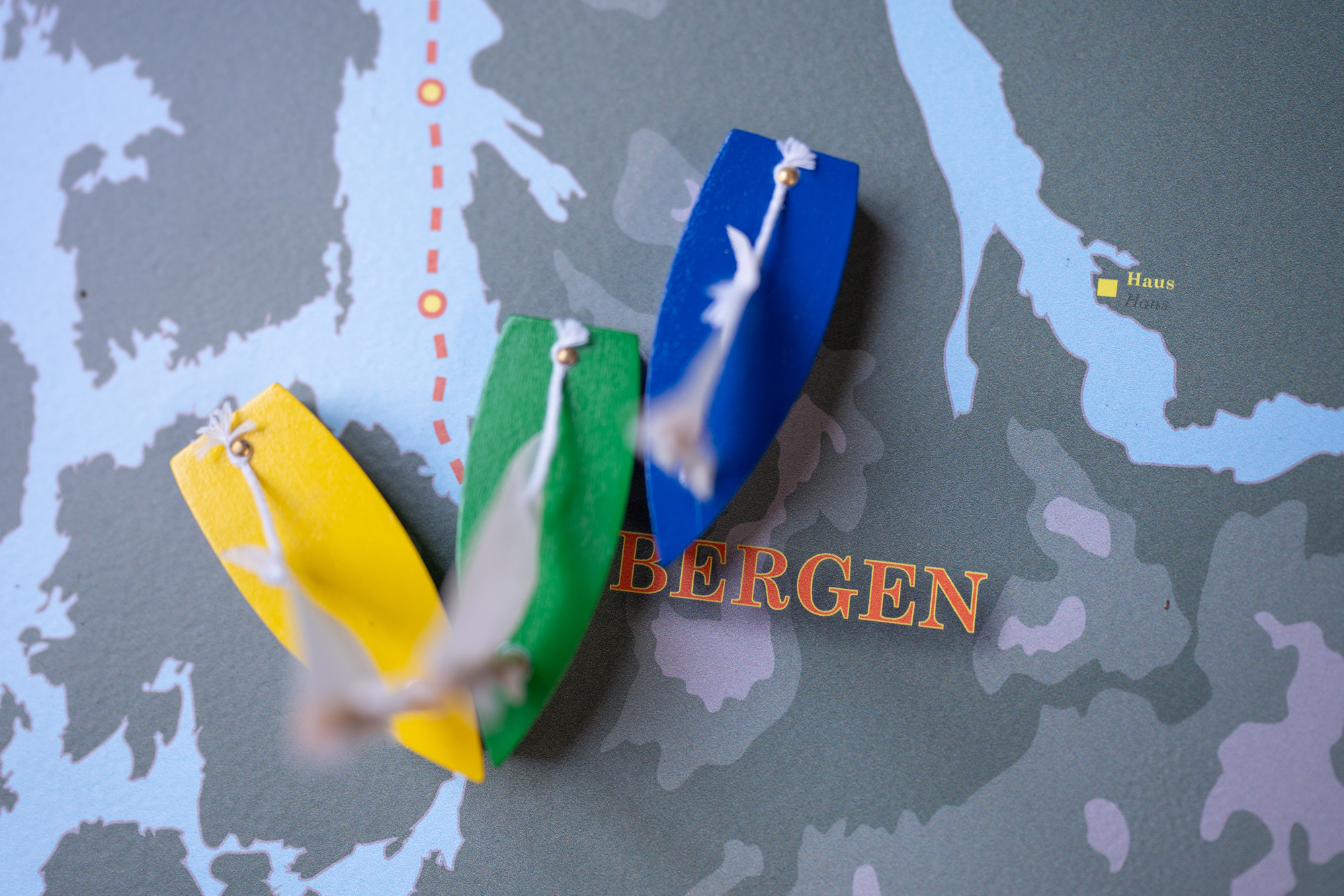Spelebrukker forma som båtar med segl, på eit spelebrett.