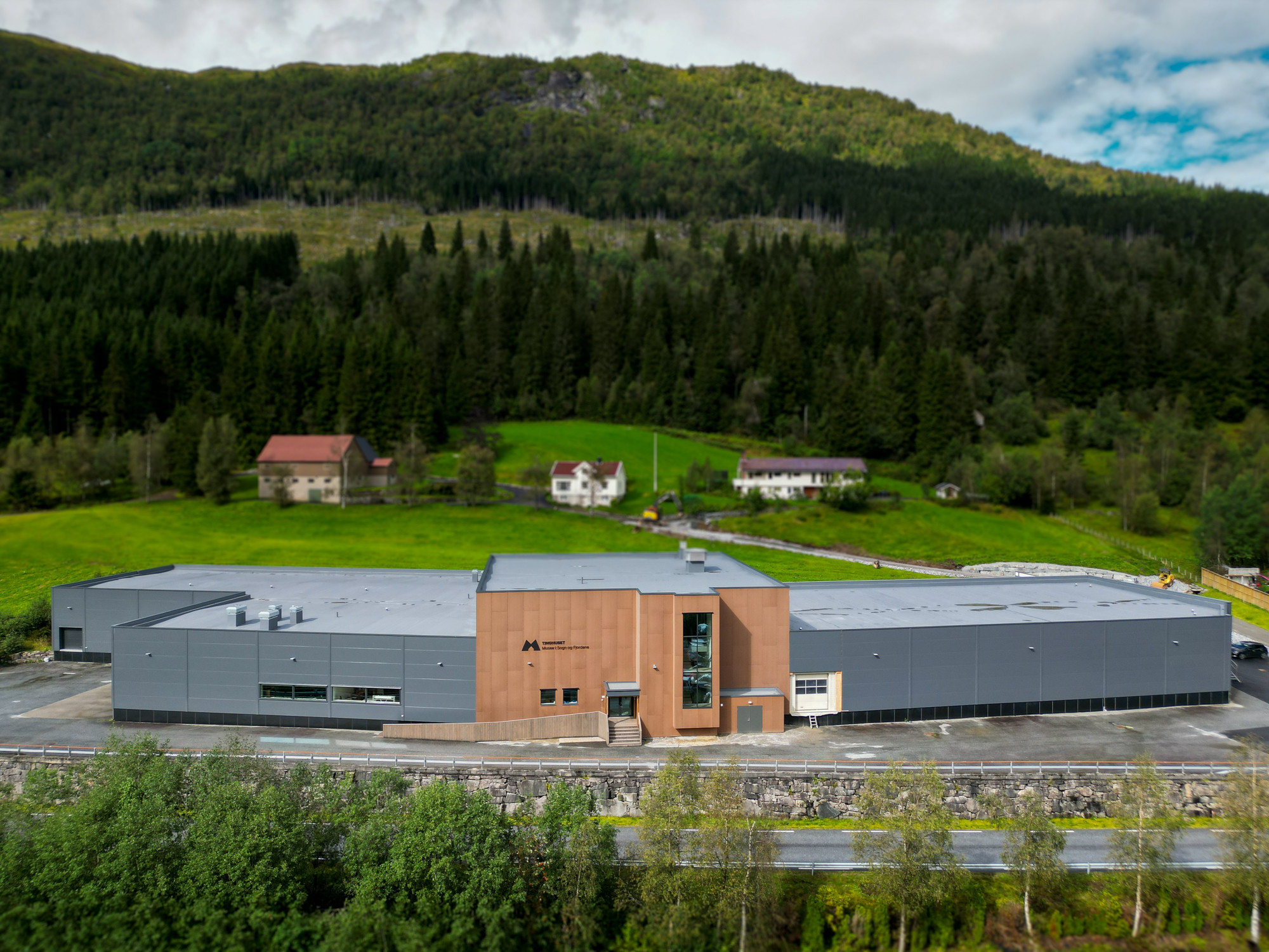 Stor grå og brun fabrikkbygning med flatt tak.