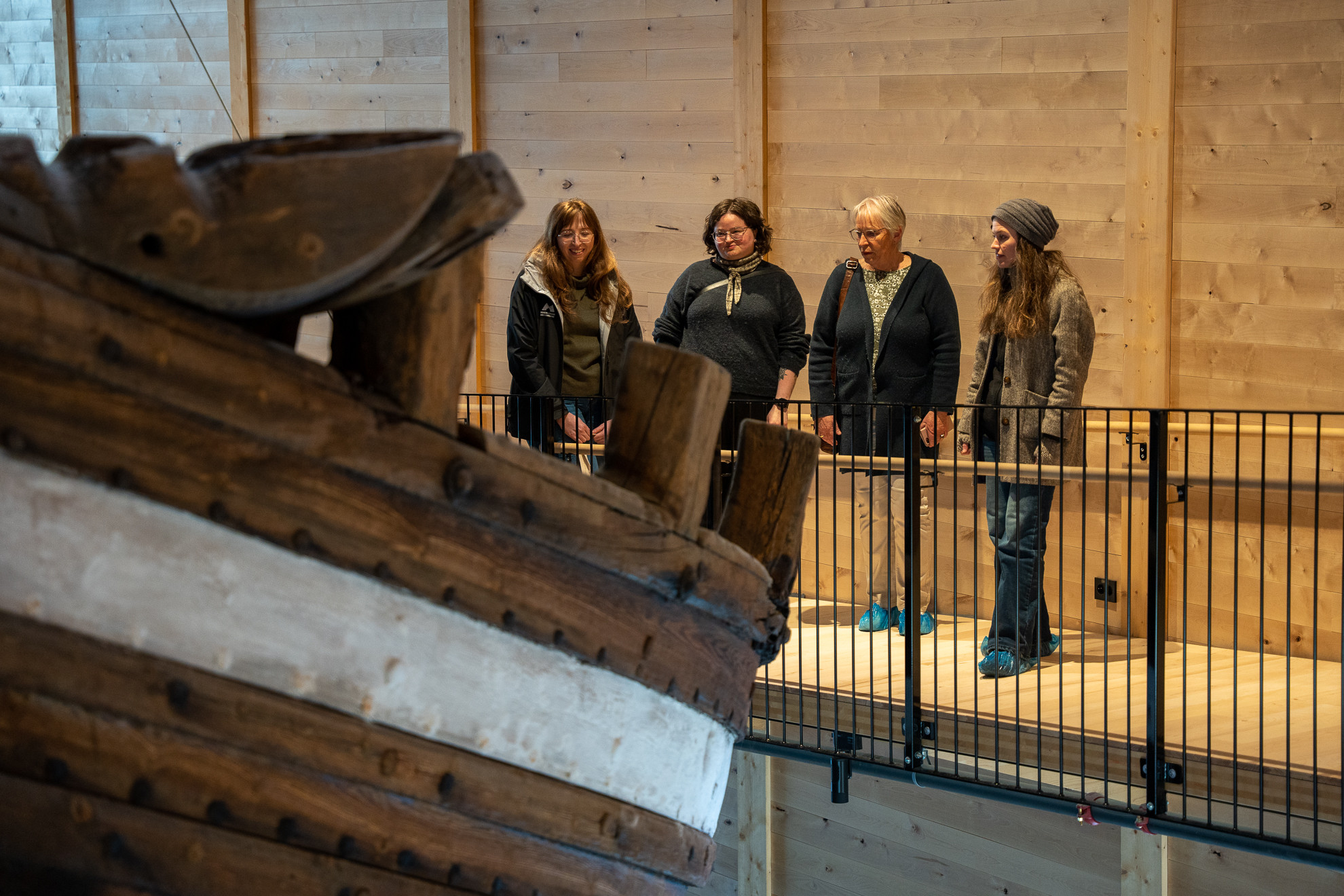 PErsonar studerer skroget på gamal skute.