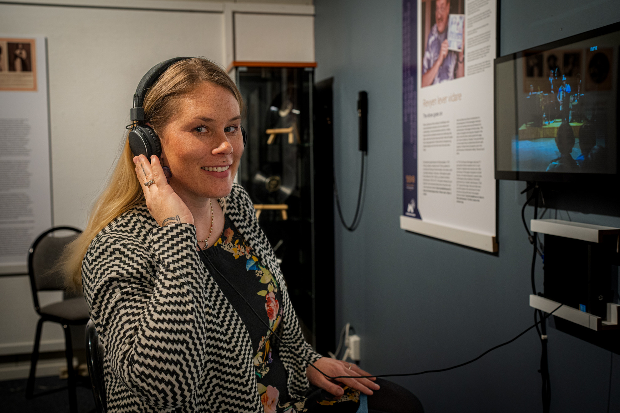 Kvinne med headset lyttar og ser på skjerm.