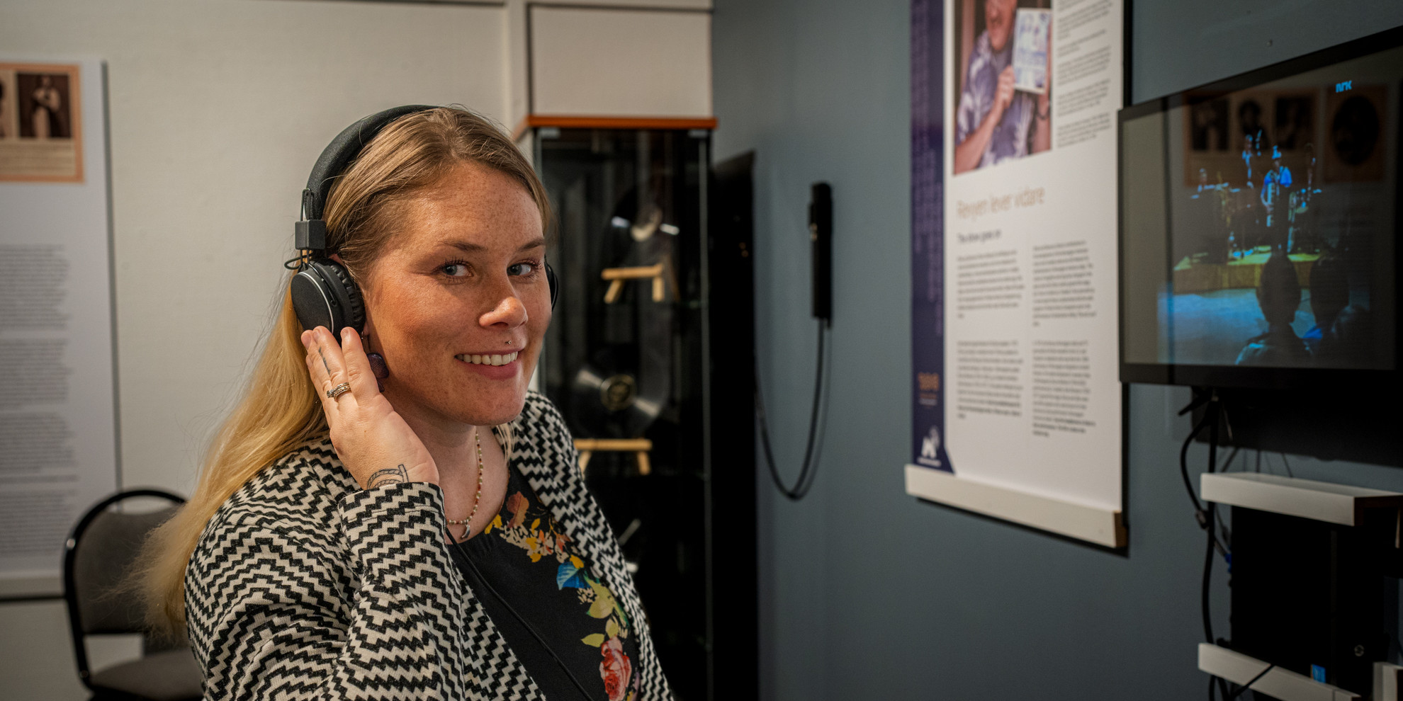 Kvinne med headset lyttar og ser på skjerm.