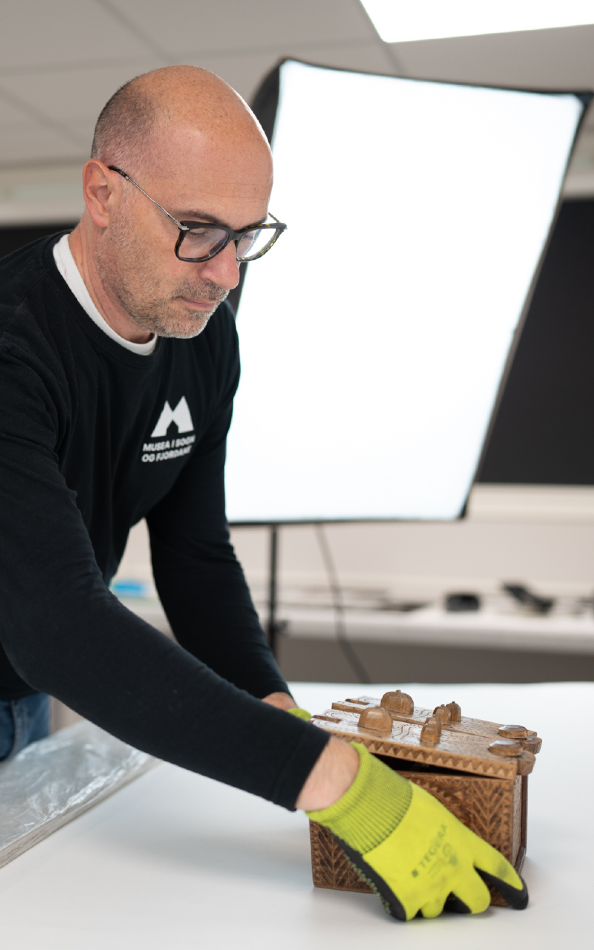 mann plasserer skrin framfor blitslampe.