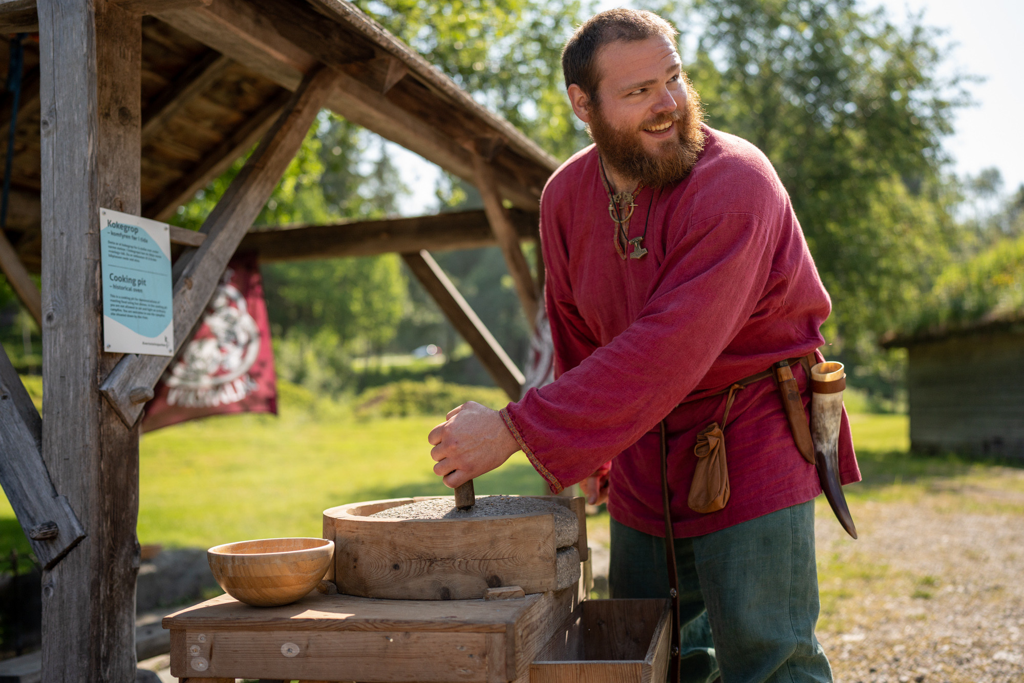 Ein mann med skjegg kledd i vikingkostyme dreg handkverna.