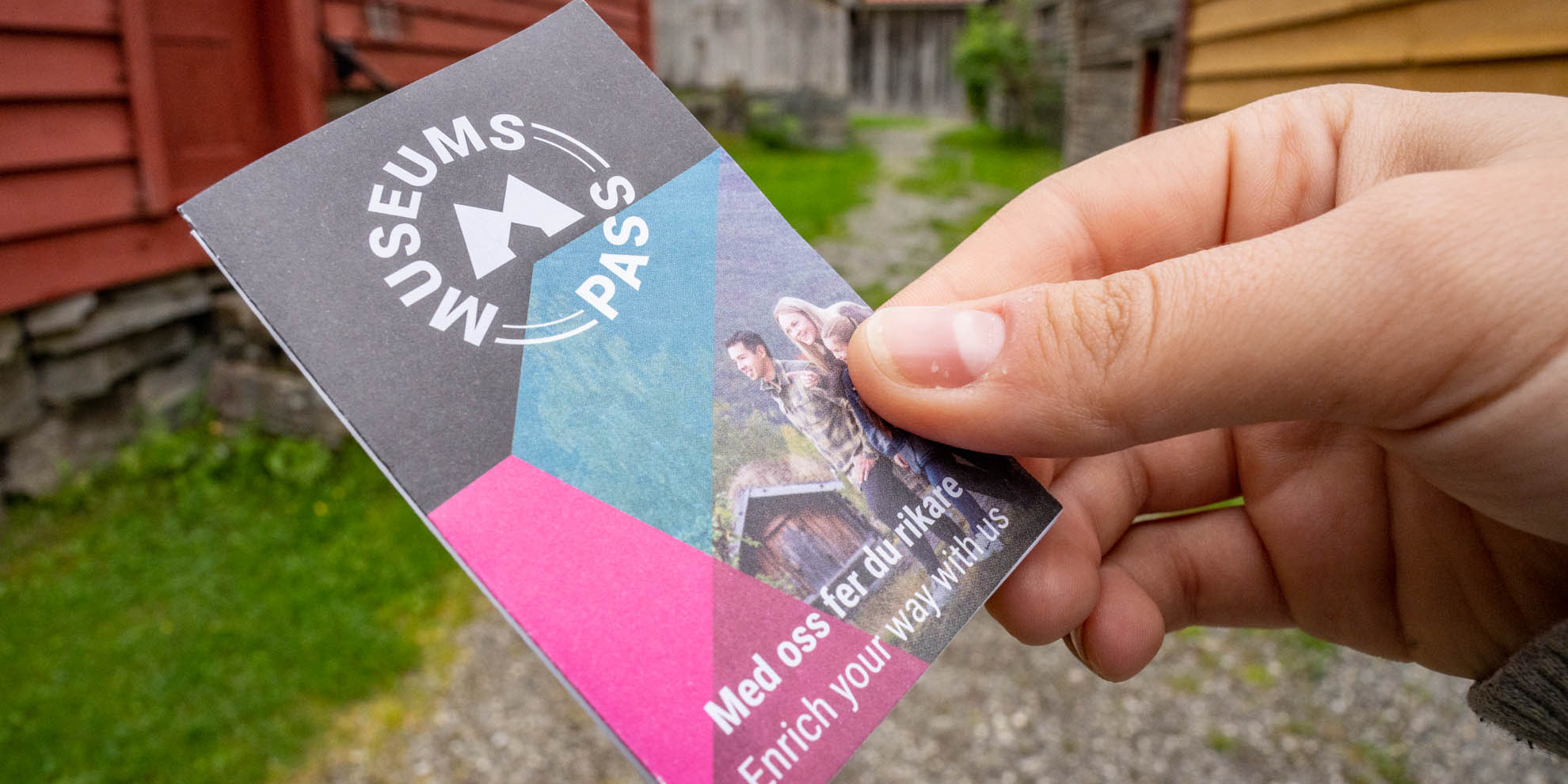 Han held ein liten trykksak det står museumspass på.