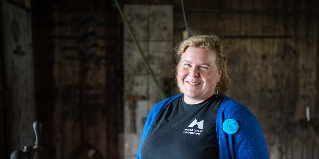 Smilande kvinne i musealt verksted