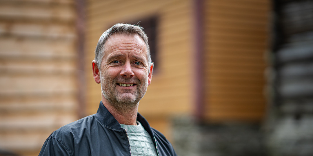 Portrett av smilande mann me grå skjeggstubbar