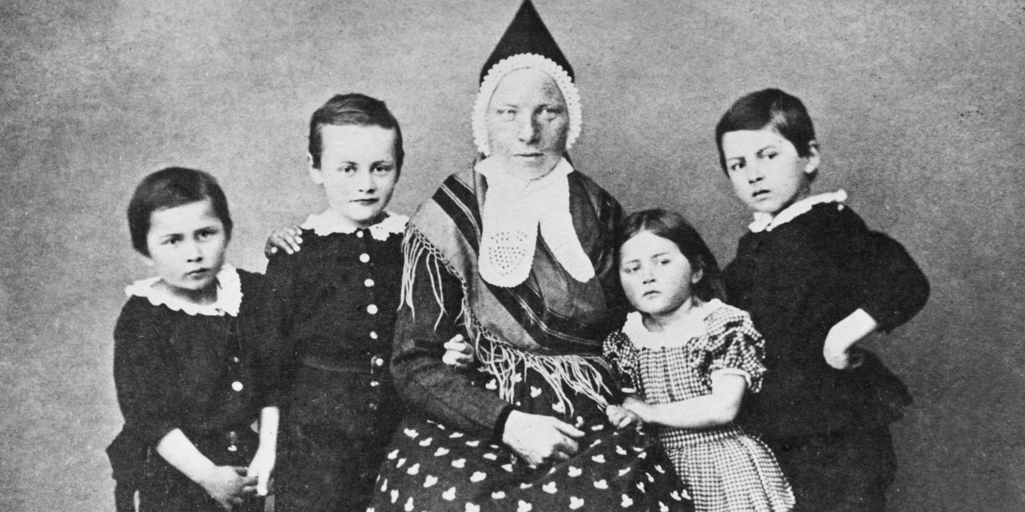 Amme / Kvinne med born: Borna til skodespelaren Prom med våtamme. Kleda hennar viser at ho er frå Sunnfjord.