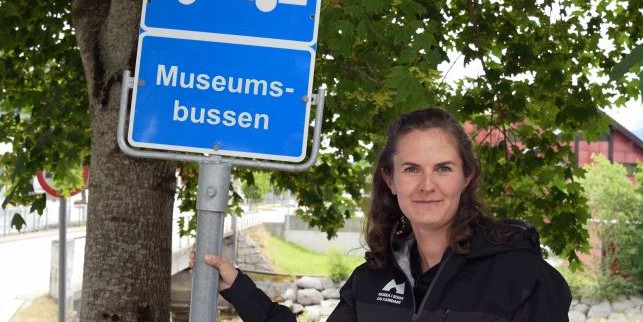 Kvinne held i buss-stoppskilt.