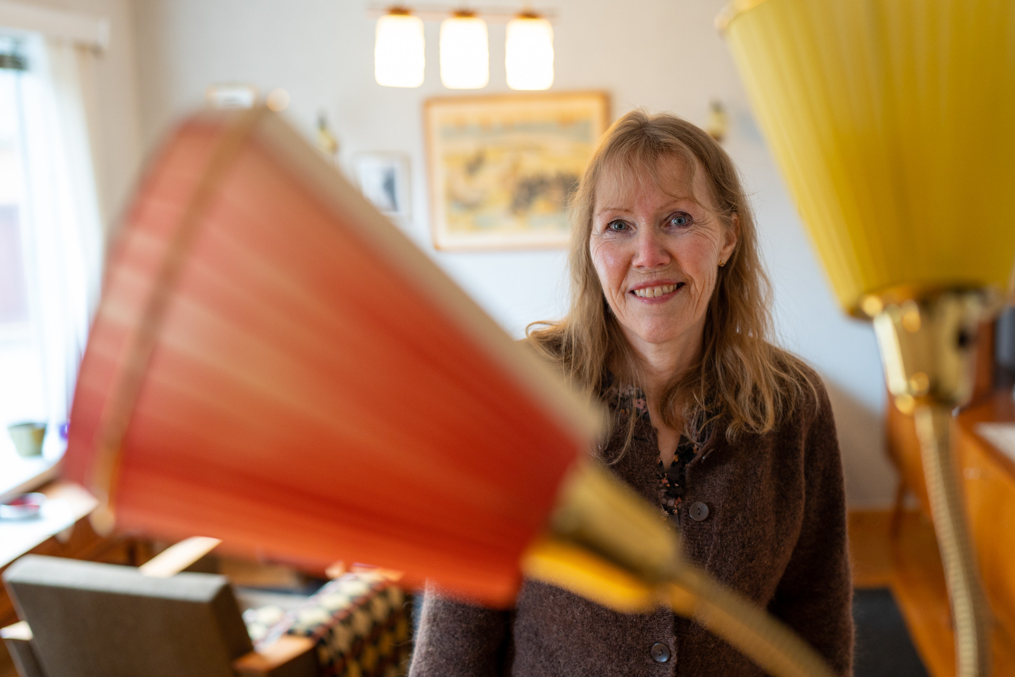 Aud Ross Solberg står bak ei klassisk 60-talslampe med fargerike lamphettar.