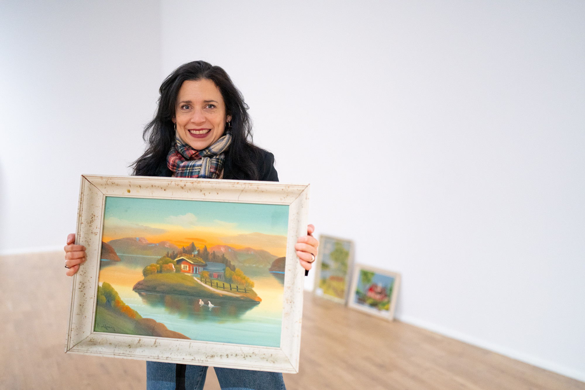 Museumsleiar Mayra Henriquez viser kvar bilda skal henge i Høgsalen.