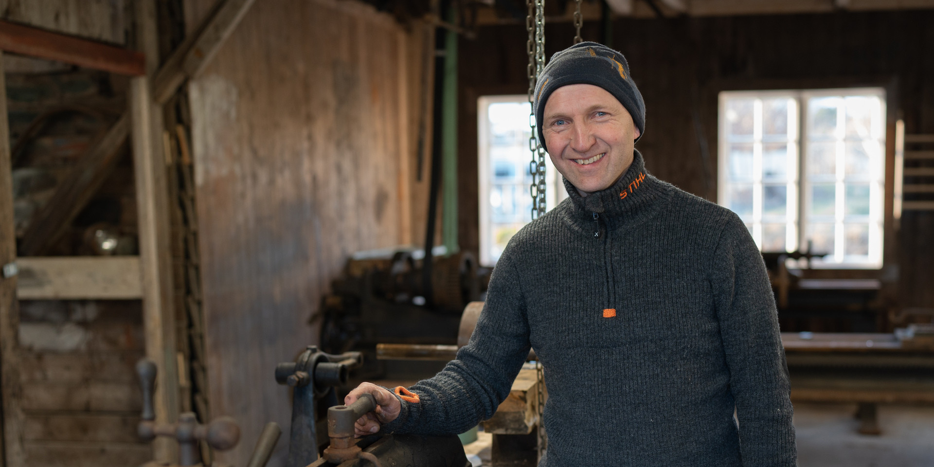 Smilande mann i mekanisk verkstad