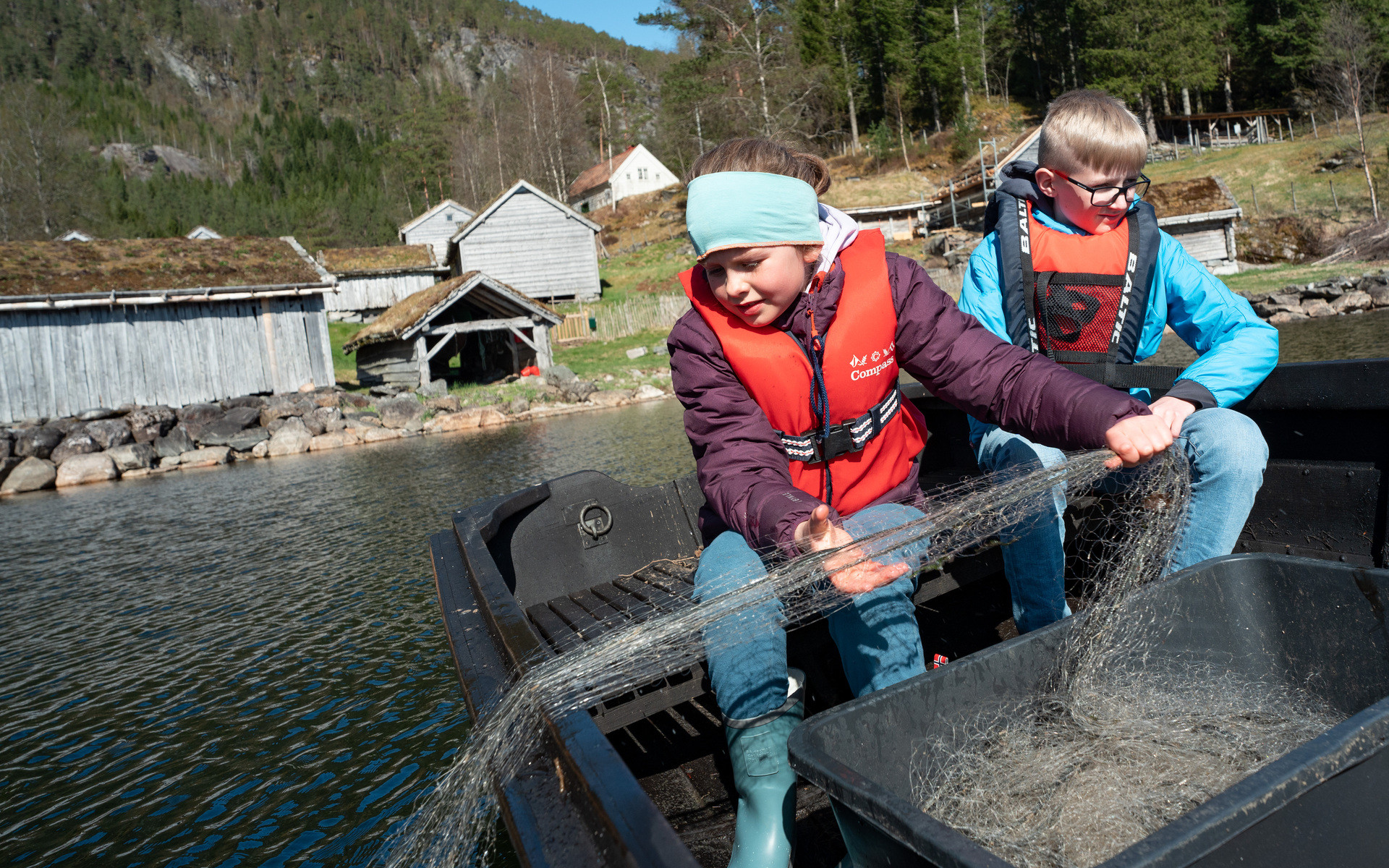 To born i båt som drar opp garn