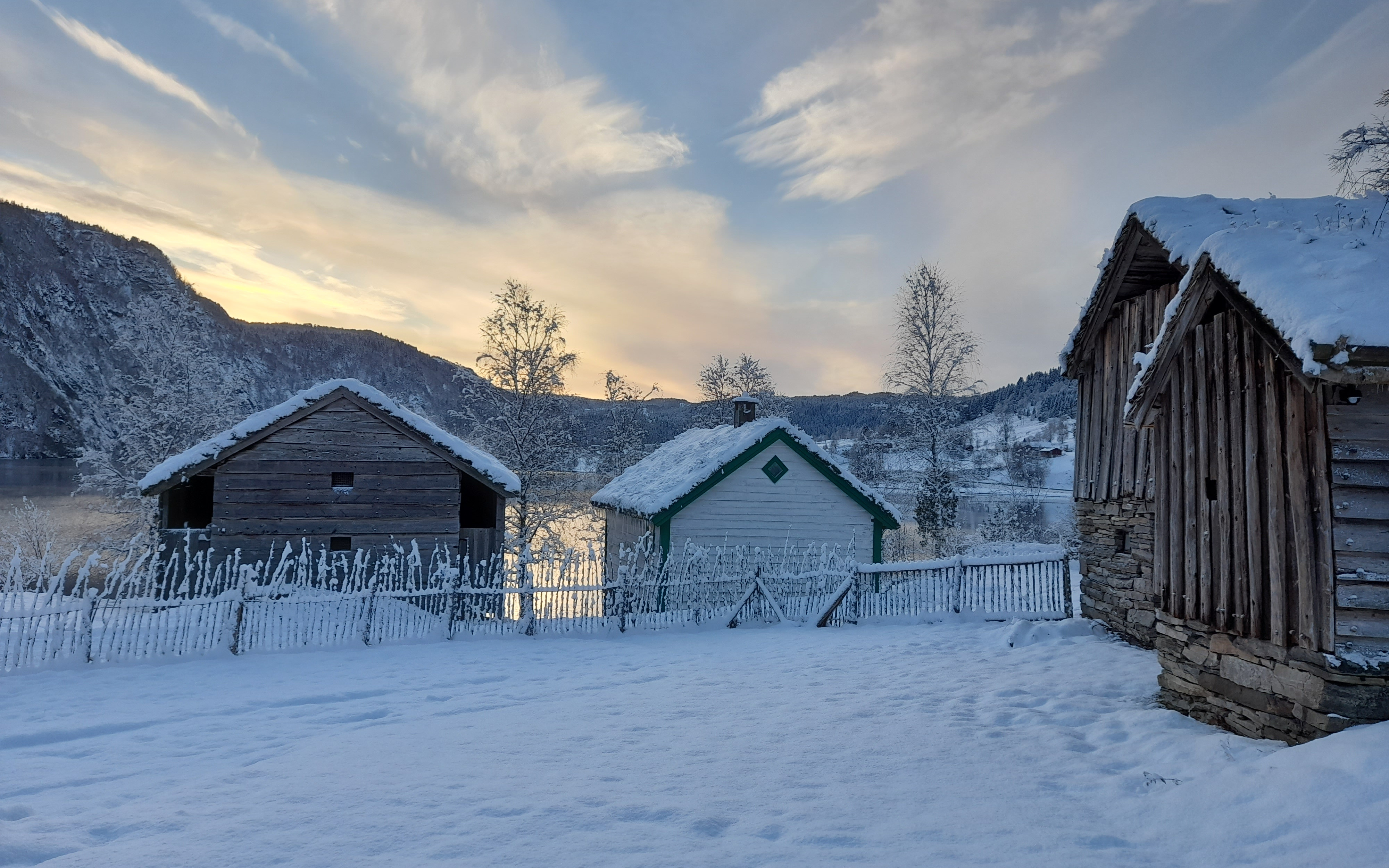 Gamle bygningar. Snø på bakken og på taka.