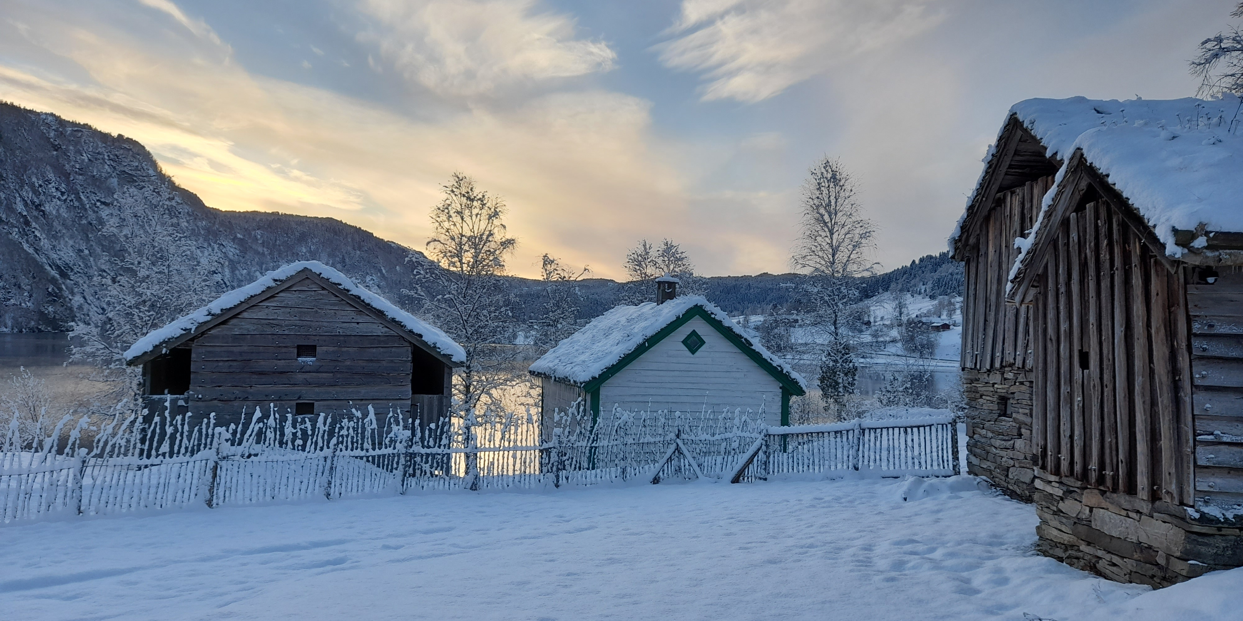 Gamle bygningar. Snø på bakken og på taka.