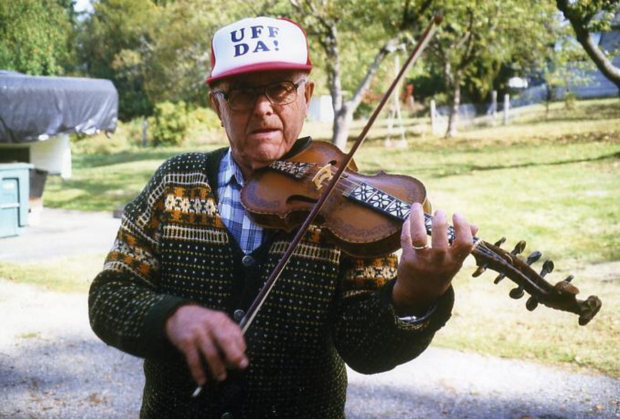 Ein eldre mann spelar hardingfele.