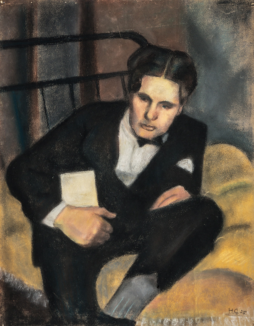 Ein ung mann i dress sit på ei sprinkelseng med gult teppe.